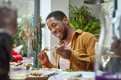 cheerful black man having lunch with family - food stock pictures, royalty-free photos & images
