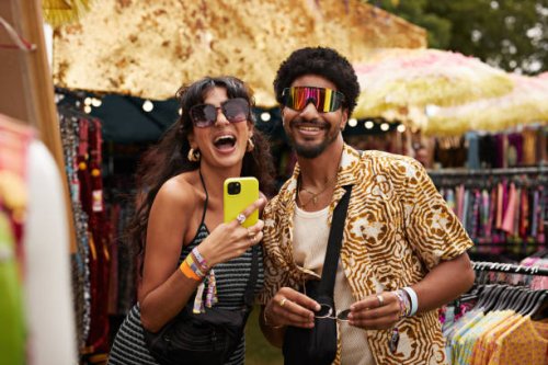 cheerful couple trying sunglasses at market stall - concert stock pictures, royalty-free photos & images