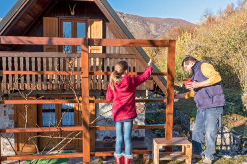 cheerful father and daughter painting wooden fence on sunny autumn day - home decoration stock pictures, royalty-free photos & images