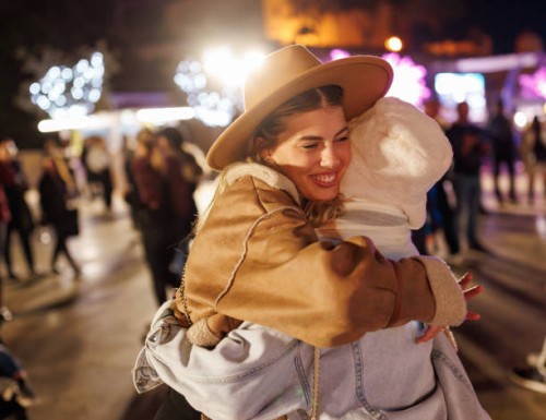 cheerful female friends hugging in amusement park in the evening - concert stock pictures, royalty-free photos & images