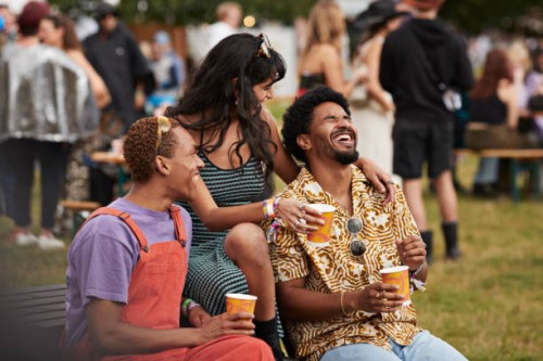 cheerful friends sitting with disposable cups - concert photos et images de collection