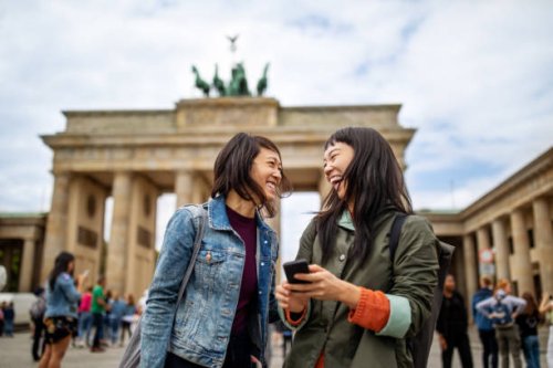 cheerful friends standing against brandenburg gate - travel stock pictures, royalty-free photos & images