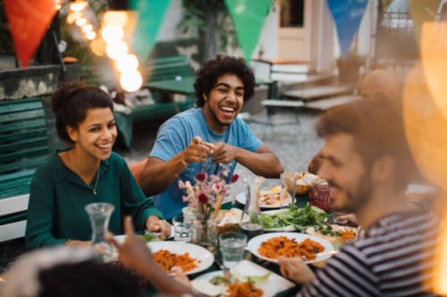 cheerful male and female friends enjoying during dinner party in backyard - garden decoration stock pictures, royalty-free photos & images