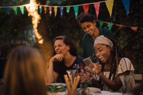 cheerful multi-ethnic friends enjoying at table during dinner party in backyard - garden decoration stock pictures, royalty-free photos & images