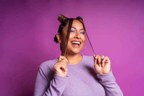 cheerful plus size woman playing with hair on purple background - fashion stock pictures, royalty-free photos & images