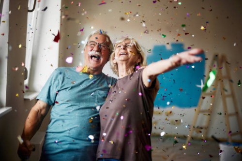 cheerful senior couple among confetti during home renovation process. - home decoration stock pictures, royalty-free photos & images