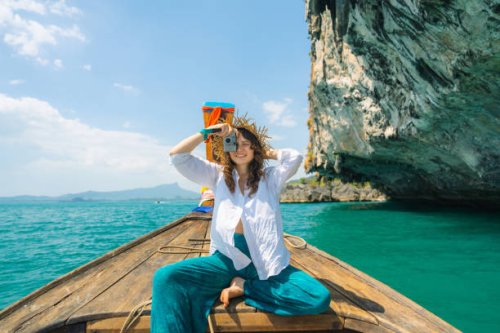 cheerful woman traveling with thai taxi boat and photographing with point and shoot camera - travel stock pictures, royalty-free photos & images