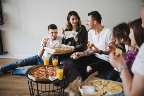 cheerful young friends eating fresh pizza. - junk food stock pictures, royalty-free photos & images