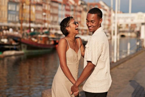cheerful young man and woman holding hands - travel stock-fotos und bilder