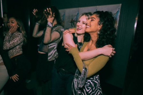 cheerful young women embracing while enjoying at nightclub - concert stock pictures, royalty-free photos & images