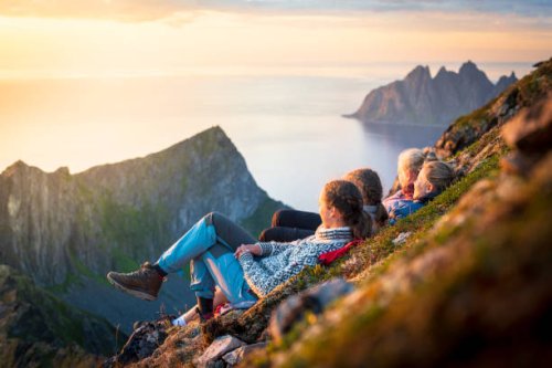 cheerful young women watching sunset, senja island, norway - travel stock pictures, royalty-free photos & images