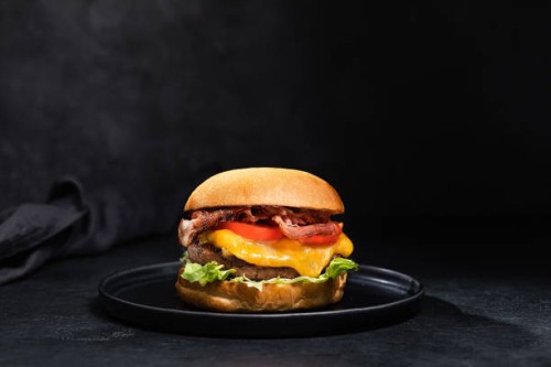 cheese burger with bacon on black dark background - junk food stock pictures, royalty-free photos & images