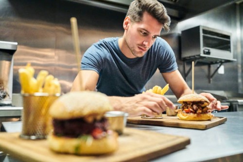 chef bereiding hamburger in commerciële keuken - junk food stockfoto's en -beelden