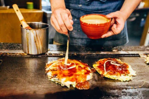 chef cooking okonomiyaki at japanese restaurant - junk food stock pictures, royalty-free photos & images