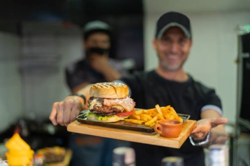 chef of a fast food restaurant proudly show the food they cooked - junk food stock pictures, royalty-free photos & images