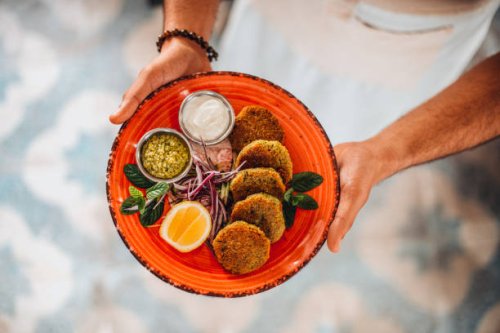 chef offers his prepared falafel plate - food stock pictures, royalty-free photos & images