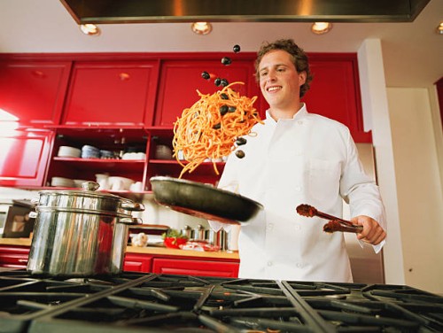 chef tossing spaghetti and olives from pan - food stock pictures, royalty-free photos & images