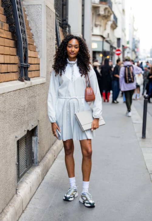Cheyenne Maya Carty wears brown bag, white dress with zipper long sleeves outside Lacoste during Womenswear Spring/Summer 2025 as part of Paris...
