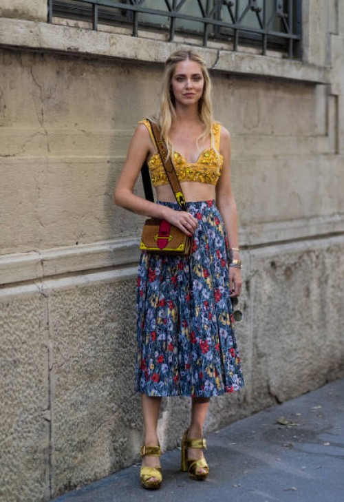 Chiara Ferragni wearing a golden cropped top, skirt with floral print and Prada bag is seen outside Prada during Milan Men's Fashion Week...