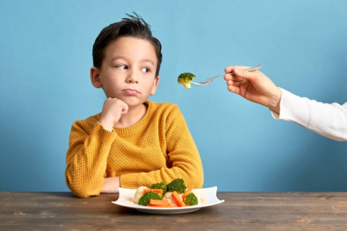 child is very unhappy with having to eat vegetables. - food stock pictures, royalty-free photos & images