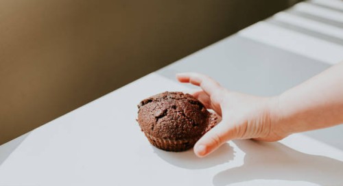 child's hand reaching for a chocolate chip bun - junk food stock pictures, royalty-free photos & images