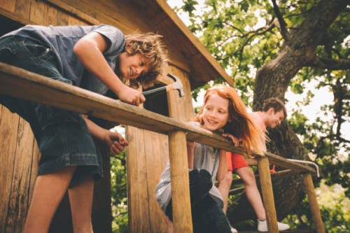 childhood friends hammering and working to build their treehouse - home decoration stock pictures, royalty-free photos & images