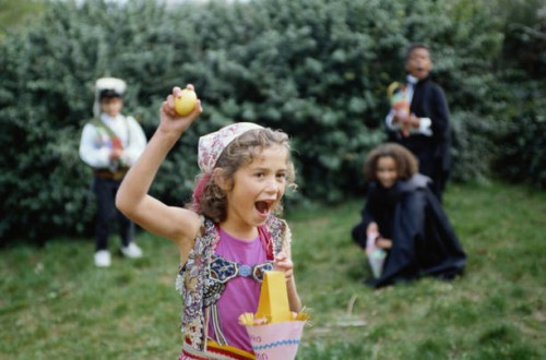 children in costumes hunting for eggs - garden decoration stockfoto's en -beelden