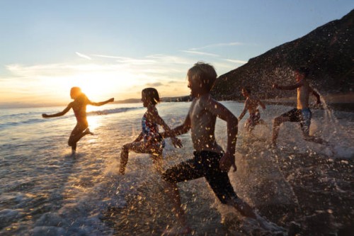 children running into sea at sunset - travel photos et images de collection