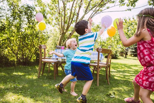 children trying to catch soap bubbles in garden - garden decoration stock pictures, royalty-free photos & images