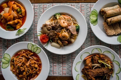 chinese food on plates in restaurant - junk food stock pictures, royalty-free photos & images