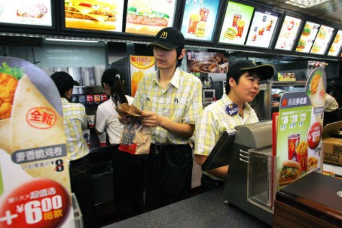 Chinese workers go about their business behind the counter at a branch of US fastood giant McDonalds in Beijing, 02 April 2007. Chinese labour...