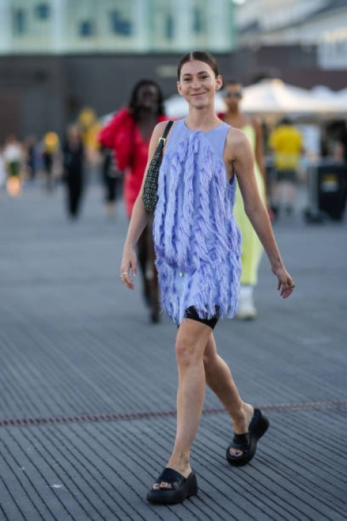 Chloé Ambre Maurin wears a pale purple sleeveless / embroidered fringed / short dress, black cyclist shorts, a black and beige FF monogram print...