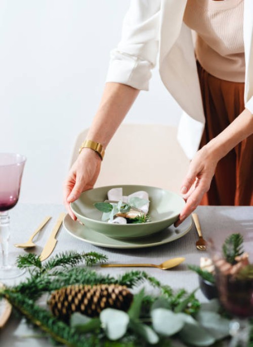 christmas celebration: an anonymous woman setting up christmas dinner table - home decoration stock pictures, royalty-free photos & images