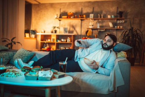 chubby guy changing channels - junk food stock pictures, royalty-free photos & images