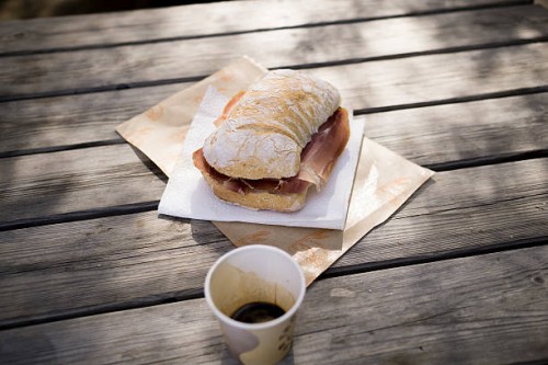 ciabatta with parma ham on wooden table outdoors - junk food stock pictures, royalty-free photos & images
