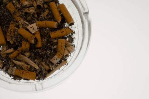 cigarette butts in ashtray - junk food stock-fotos und bilder