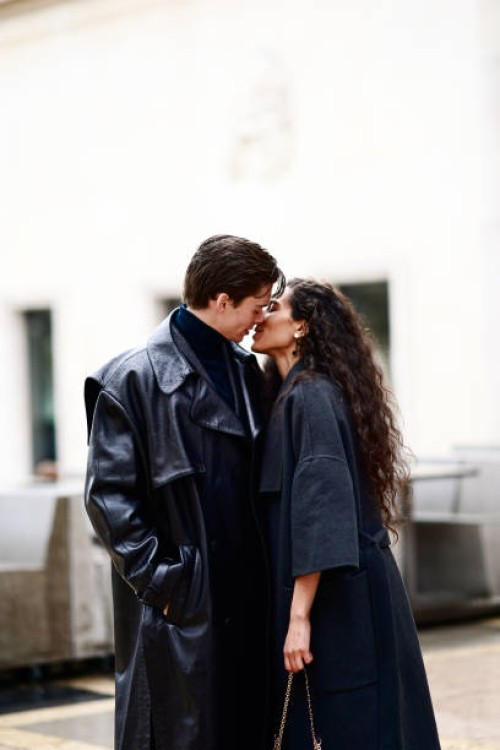Ciinderella B wears a gray long coat ; Mathias Le Fevre wears a black leather long coat and a turtleneck pullover, outside Rokh, during Paris Fashion...