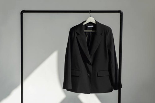 classic black jacket hanging on the shoulder on a rail. - fashion stock pictures, royalty-free photos & images