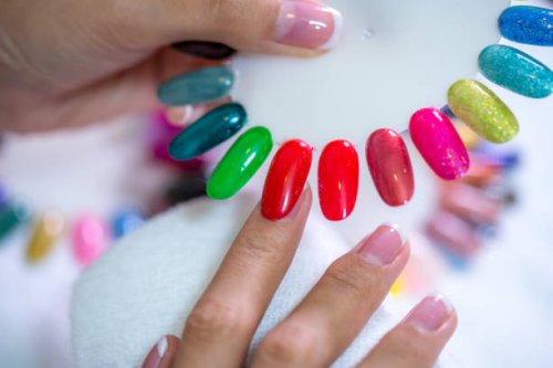 client choosing color of nail polish for manicure from palette colors. close up, only hands on white table visible. nail art, hands care, beauty concept. - nails art stock pictures, royalty-free photos & images