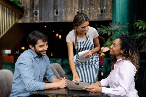 clients at a restaurant asking questions about the menu to the waitress - food stockfoto's en -beelden
