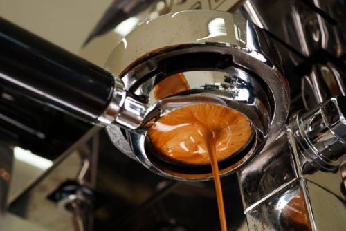 close-up and a tight shot of pulling espresso and crema being extracted from a portafilter. - coffee stock pictures, royalty-free photos & images
