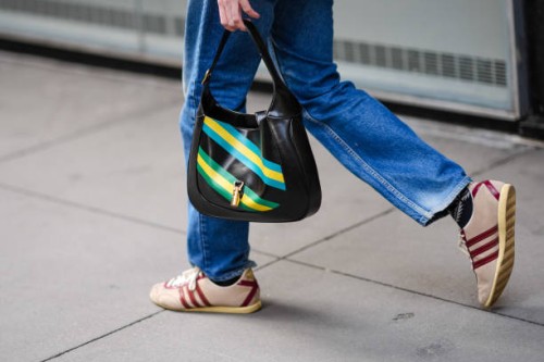 Close-up detail view of a black leather Gucci bag with yellow and blue printed stripes, during New York Fashion Week, on February 12, 2024 in New...