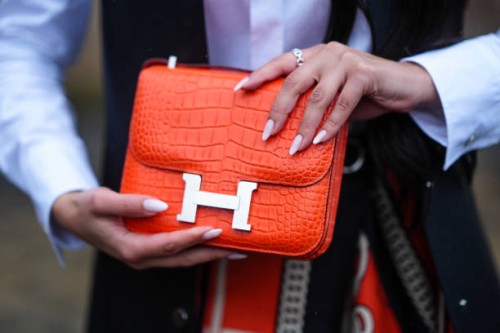 Close-up detail view of an orange crocodile pattern leather Hermes bag, outside Hermes, during the Womenswear Fall/Winter 2024/2025 as part of Paris...
