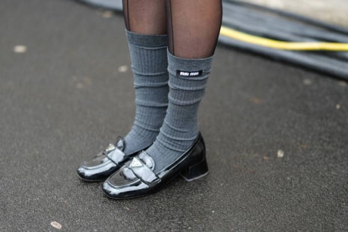 Close-up detail view of gray Miu Miu socks and Prada leather loafers high heels shoes, outside Prada, during the Milan Fashion Week Menswear...