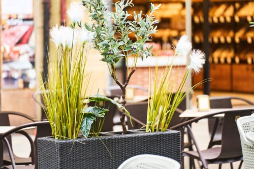 close-up front view of a basket with plants and tables outside a building with no people around. - garden decoration stock pictures, royalty-free photos & images