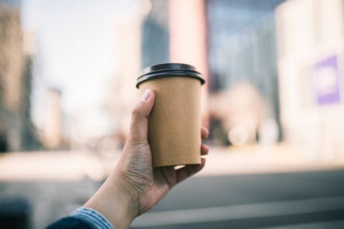 close-up of a businessman holding recycable takeaway coffee cup - junk food stock pictures, royalty-free photos & images