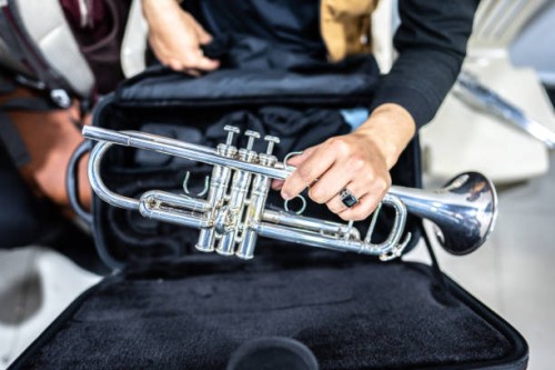 close-up of a human hand holding a trumpet in the backstage of the music concert - concert stock pictures, royalty-free photos & images