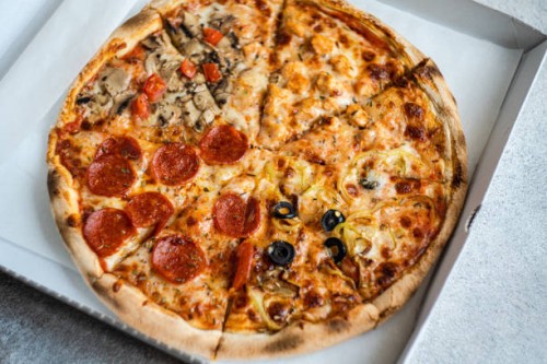 close-up of a take away pizza with different toppings in a cardboard pizza box - junk food stock pictures, royalty-free photos & images