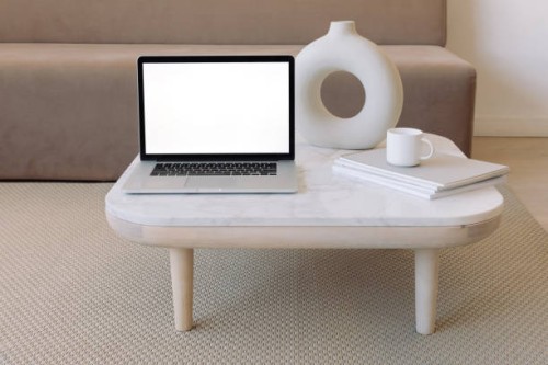 close-up of an open laptop computer on a coffee table next to a ceramic vase and a cup on a stack of books - home decoration stock pictures, royalty-free photos & images