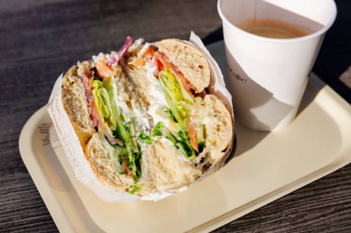 close-up of bagel with salmon and cream cheese and coffee - junk food stock pictures, royalty-free photos & images